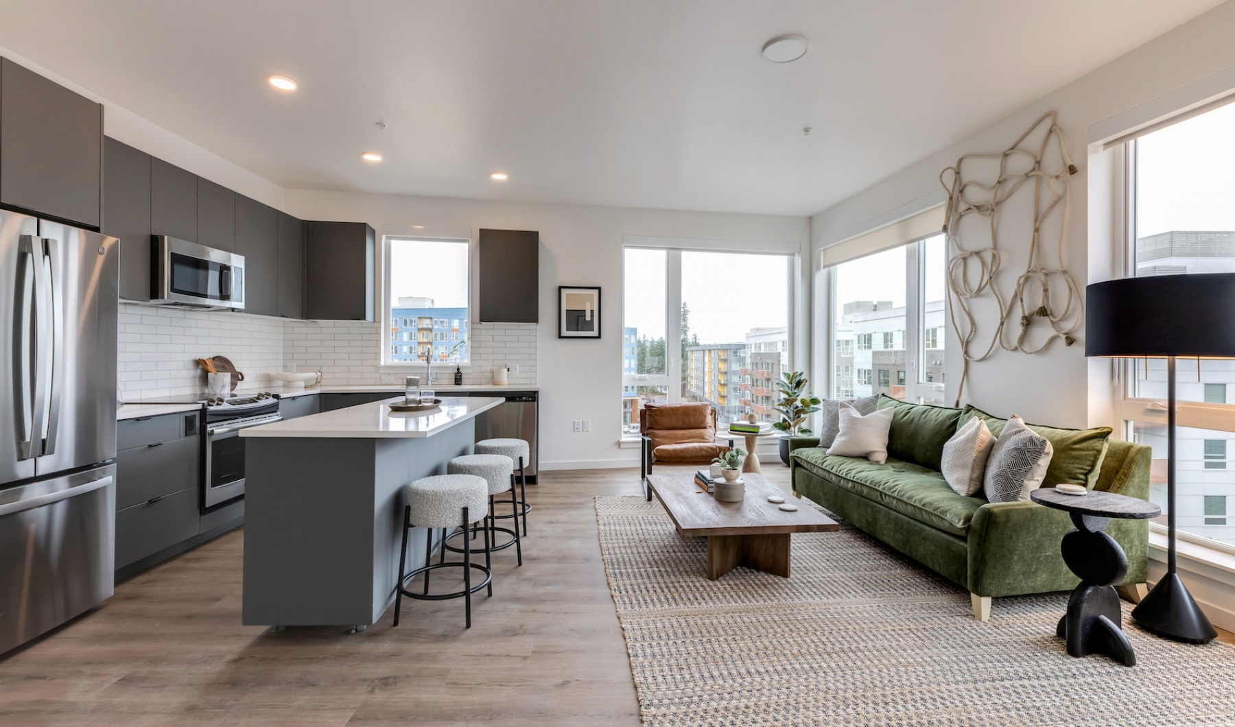 kitchen with island and quartz countertops, and spacious living area with huge windows